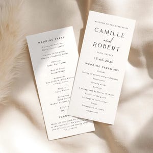 May include: Two wedding ceremony programs on a cream background. The programs feature black text with the names "Camille and Robert" and the date "26.06.2026". One program lists the wedding party, and the other lists the ceremony details.