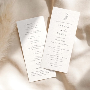 May include: Two off-white rectangular wedding programme cards with black serif text. The front card displays the names Olivia and Jamie, the date 26.06.2026, and a ceremony schedule. The second card lists the wedding party members and a thank you note.