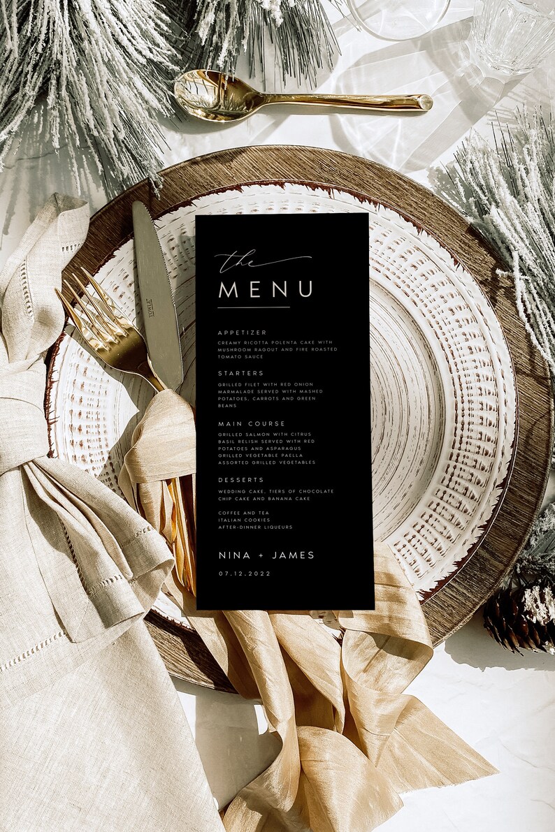 May include: A black and white wedding menu card with the words "the MENU" in a handwritten font. The menu includes appetizers, starters, main course, desserts, coffee and tea, and after-dinner liqueurs. The names Nina and James are at the bottom of the card with the date 07.12.2022.
