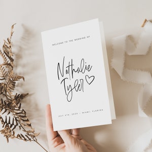 Peut inclure: Carte d'invitation de mariage blanche avec un texte calligraphi&eacute; noir qui dit "Bienvenue au mariage de Nathalie Tyler" avec un petit symbole de c&oelig;ur. La date est le 4 juillet 2020 et le lieu est Miami, Floride.