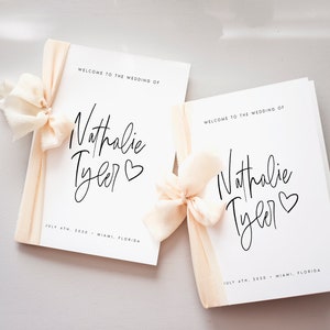 Peut inclure: Deux programmes de mariage blancs avec un ruban p&ecirc;che nou&eacute; autour. Les programmes portent le texte "Bienvenue au mariage de Nathalie Tyler" et la date "4 juillet 2030 - Miami, Floride".