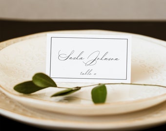May include: White place card with black border and text that reads "Sasha Johnson, table 10".
