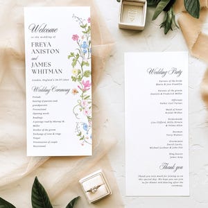 Puede incluir: Juego de papelería de boda con una tarjeta de bienvenida decorada con flores, una tarjeta con detalles de la fiesta de bodas y dos joyeros. Las tarjetas tienen una caligrafía elegante. Los joyeros son beige.