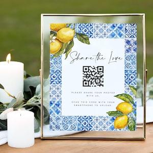 Könnte beinhalten: Ein goldfarbener Rahmen mit einem weißen Hintergrund und einem blauen und weißen Fliesenmuster als Rand. Das Schild sagt "Share the Love" und hat einen QR-Code mit dem Text "Bitte teilen Sie Ihre Fotos mit uns. Scannen Sie diesen Code mit Ihrem Smartphone, um hochzuladen."