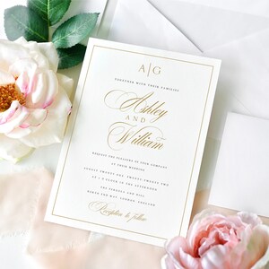May include: A white wedding invitation with gold lettering. The invitation reads "A/G Together with their families Ashley and William Request the pleasure of your company at their wedding August twenty one twenty two at o'clock in the afternoon The Pergola and Mill North End Way London England Reception to follow"