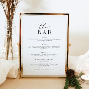 Puede incluir: Un menú de bar con marco dorado y fondo blanco. El menú enumera cerveza, vino, licores y cócteles exclusivos. El texto incluye "The Bar" en una elegante escritura. Los elementos decorativos incluyen flores secas y una vela encendida.