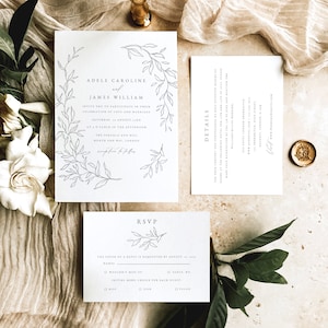 May include: A wedding invitation suite with a white background and a delicate floral design. The invitation features the names "Adele Caroline" and "James William" and the date "Saturday, August xx". The RSVP card includes a section for guests to indicate their attendance and meal preferences.