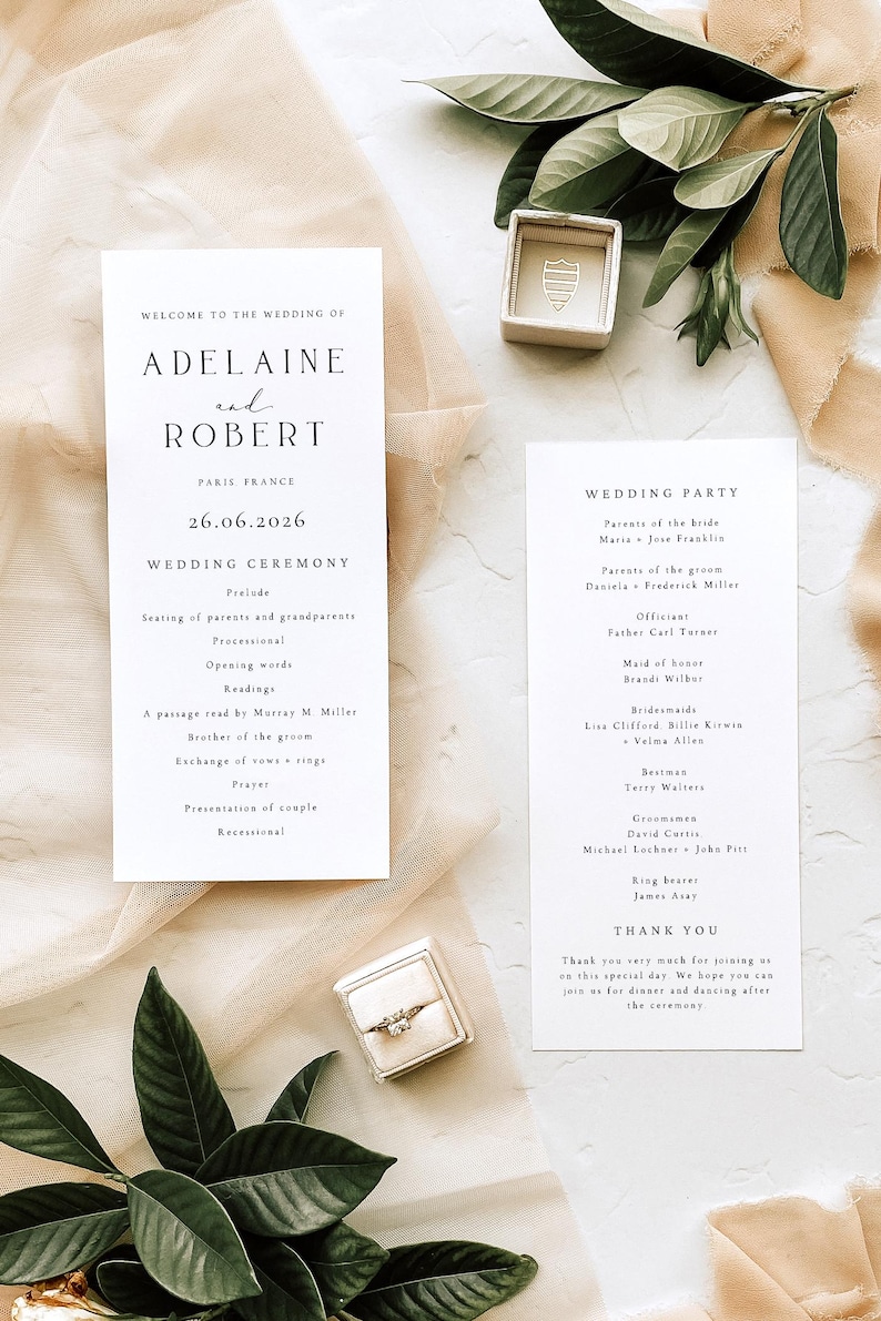 May include: Wedding stationery set featuring a wedding program, a wedding party list, and a ring box. The program lists the ceremony details, date, and names. The ring box is open, displaying a diamond ring.