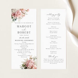 May include: A two-sided wedding programme card featuring floral illustrations of pink roses and hydrangeas at the top and bottom. The text includes the names Margot and Robert, the date 26.06.2026, a ceremony order, a wedding party list, and a thank you note.