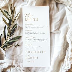 May include: A white wedding menu card with gold text. The menu includes appetizers, starters, main courses, and desserts. The names "Charlotte and Robert" and the date "26.06.2026" are also displayed.