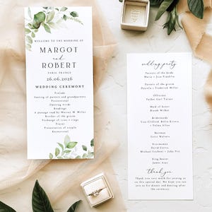 May include: Two white wedding ceremony programmes with green watercolour leaf illustrations. The left programme lists Margot and Robert, Paris France, 26.06.2026, and the ceremony order. The right programme lists the wedding party and a thank you note.