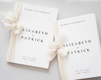 Pode incluir: Dois programas de casamento brancos com o texto "WELCOME TO THE WEDDING OF LIZABETH + PATRICK" e a data "JULY 4TH, 2020 MIAMI, FLORIDA". Cada programa é amarrado com uma fita e laço creme.