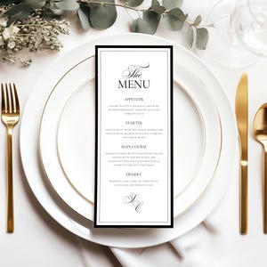 Peut inclure: Un menu formel avec une bordure noire, une écriture élégante et une liste de plats. Le menu est placé sur une assiette blanche avec des couverts dorés et des décorations végétales, parfait pour un mariage ou un événement spécial.