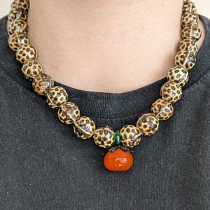 TOMATINA is where wild meets whimsy – it’s a cheeky statement piece that blends playfulness with untamed boldness.
Round ceramic beads in a wild leopard print radiate fierce vibes, while the glossy tomato-shaped glass pendant adds an unexpected, pop of juicy charm. A true statement piece that doesn’t take itself too seriously: ideal for confident looks with a sense of humor, sultry Italian summer nights, or anyone who loves to wear their passion and wild side with a wink. 🐆🍅