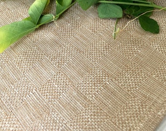 May include: A close-up of a variety of flowers and leaves on a beige textured surface. The flowers include a blue butterfly pea flower, a yellow flower with spiky petals, and green leaves.