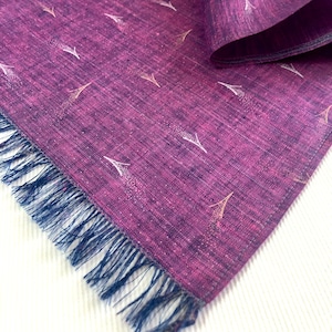 May include: A purple silk scarf with a white and gold Eiffel Tower pattern. The scarf has a fringed edge.