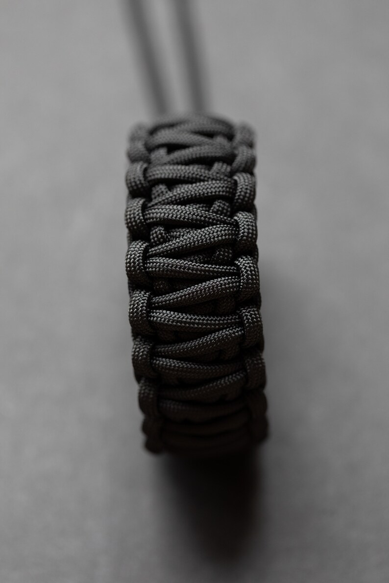 May include: A black paracord bracelet with a woven design.