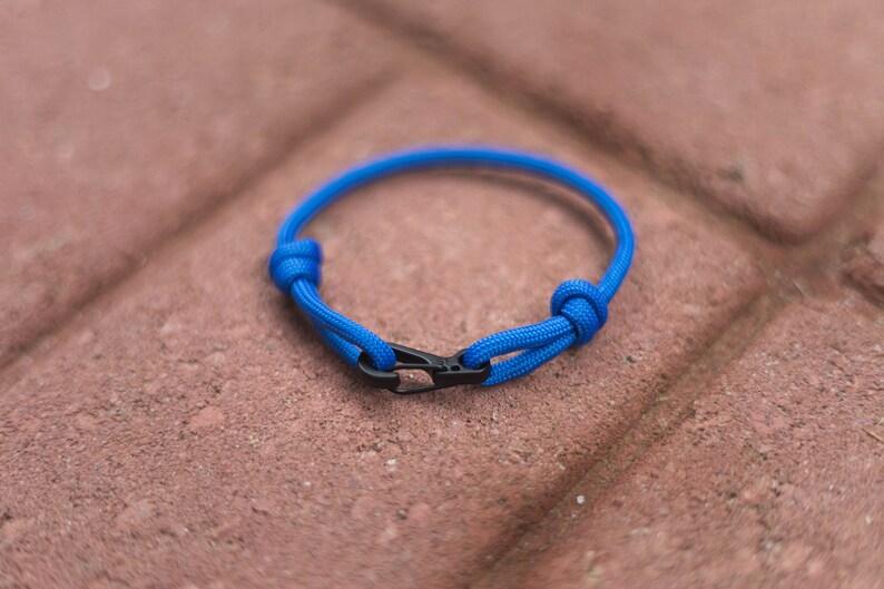 Pode incluir: Um bracelete de paracord azul com um fecho preto.