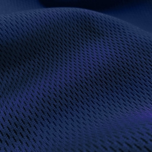 May include: Close-up of a dark blue fabric with a textured, mesh-like pattern. The fabric has a slight sheen and is soft to the touch.