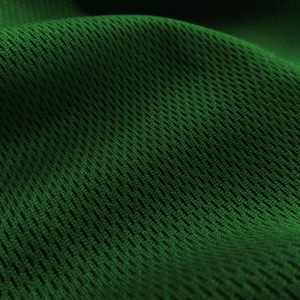 May include: Close-up of a green mesh fabric with a textured pattern. The fabric is soft and flexible, making it ideal for athletic wear or other garments.