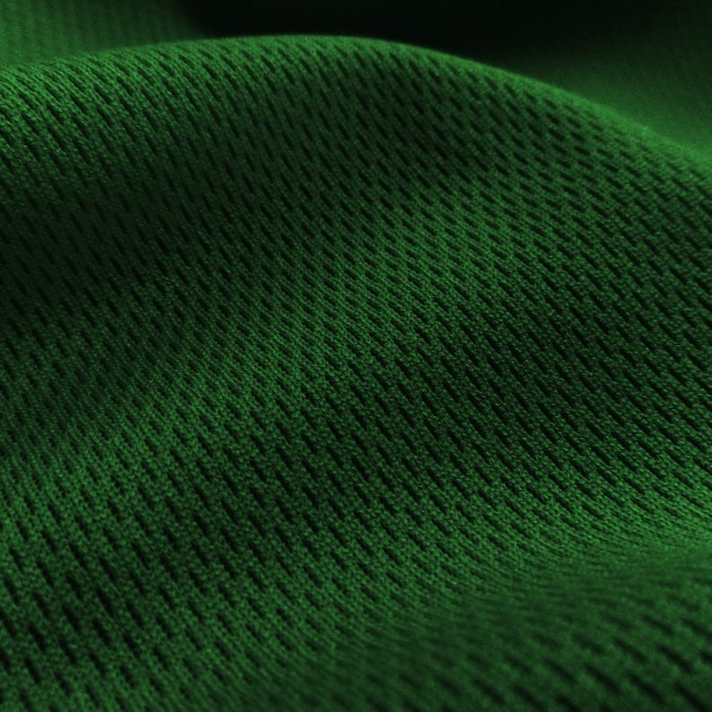 May include: Close-up of a green mesh fabric with a textured pattern. The fabric is soft and flexible, making it ideal for athletic wear or other garments.