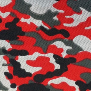 May include: Red, white, and black camouflage pattern fabric. The fabric has a mesh texture.