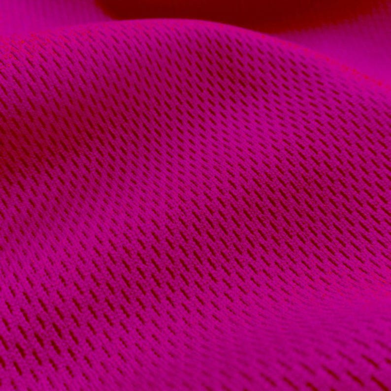 May include: Close-up of a bright pink fabric with a textured, woven pattern.