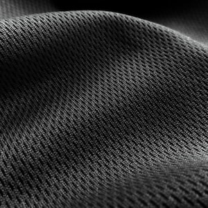 May include: Close-up of a black, textured fabric with a grid pattern. The fabric is soft and flexible, and it has a slightly shiny finish.