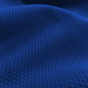 May include: Close-up of a blue fabric with a textured, woven pattern. The fabric has a slightly rippled surface.