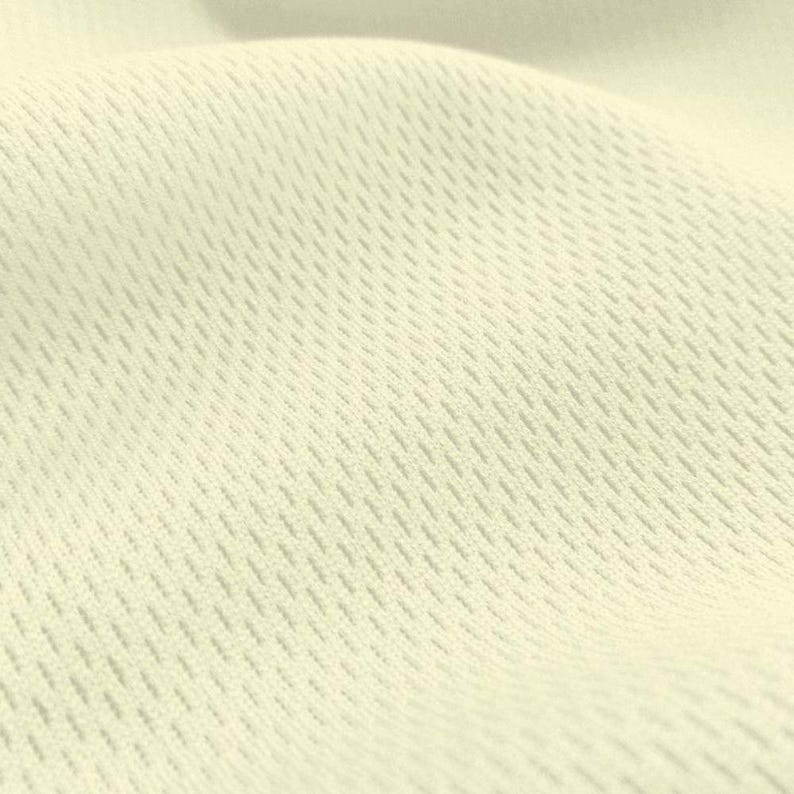 May include: Close-up of a cream-colored fabric with a textured, woven pattern. The fabric has a subtle sheen and a soft, smooth feel.