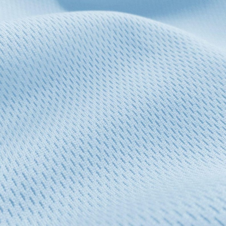 May include: Close-up of a light blue fabric with a textured, woven pattern. The fabric has a soft, smooth feel.