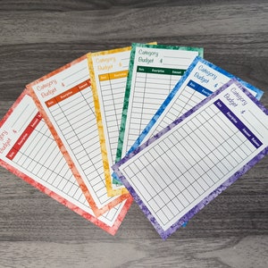 May include: Six colorful budget trackers with a watercolor design. Each tracker has a heading that says "Category Budget $".