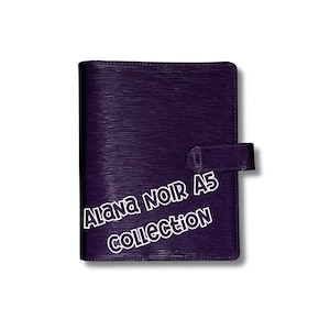May include: A dark purple A5 planner from the Alana Noir Collection. The planner has a textured surface and a snap closure. The text "Alana NOIR A5 COLLECTION" is displayed in white.