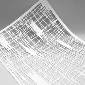 May include: White paper with a geometric pattern of intersecting lines, creating a grid-like design. The lines are cut out of the paper, creating a delicate and intricate pattern.