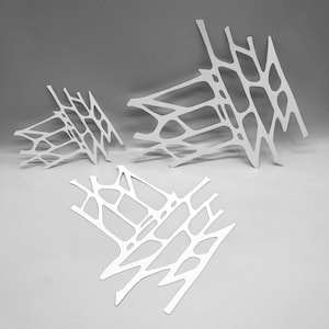 Puede incluir: Tres esculturas blancas abstractas con un diseño similar a una red. Las esculturas están dispuestas en diferentes ángulos, creando una composición dinámica sobre un fondo neutro. Las formas tienen una estética moderna y artística.