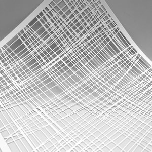 Könnte beinhalten: Ein weißer Papierauschnitt mit einem Gittermuster aus sich kreuzenden Linien. Die Linien bilden ein gewebtes oder netzartiges Design mit unterschiedlichen Dichten und Winkeln. Das Papier ist leicht gebogen, was dem Kunstwerk Tiefe und Dimension verleiht.