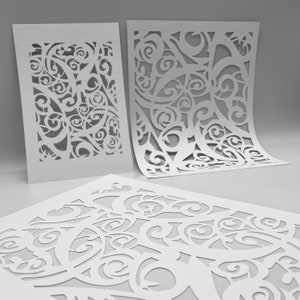 Puede incluir: Tres recortes de papel blanco con intrincados patrones en espiral. Los recortes están dispuestos en forma escalonada, con el recorte superior ligeramente curvado.