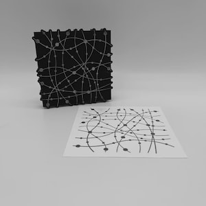 Puede incluir: Un bloque de impresión cuadrado negro con un patrón en relieve de color plateado de líneas curvas que se cruzan y pequeños nodos circulares, acompañado de una impresión en papel blanco que muestra el mismo diseño en tinta negra.
