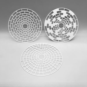 May include: Three white, circular decorative pieces with a brick-like pattern. The designs are laser-cut, featuring concentric circles of rectangular shapes. The pieces vary slightly in their brick arrangement, creating a unique visual texture.