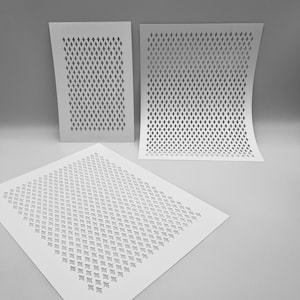 May include: Three white stencils with a repeating diamond pattern. The stencils are arranged at different angles, with one flat on the surface and the other two slightly curved. The cut-out design is visible against a neutral background.