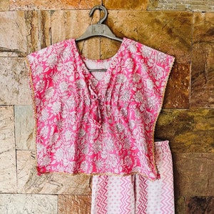 May include: A pink and white printed pajama set with a floral top and chevron patterned pants. The top has a V-neck and short sleeves. The pants have a straight leg.