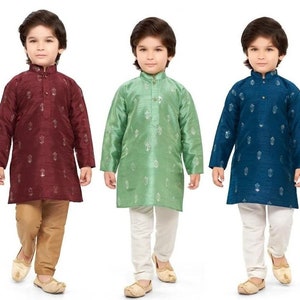 May include: Three young boys wearing traditional Indian clothing. The boys are wearing long-sleeved shirts with a button-up collar and pants. The shirts are patterned with small floral designs. The boys are wearing different colored shirts: maroon, green, and blue.