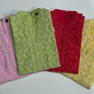 May include: Four embroidered tunics in pink, green, red, and yellow with white floral patterns. The tunics have a mandarin collar and button closure.