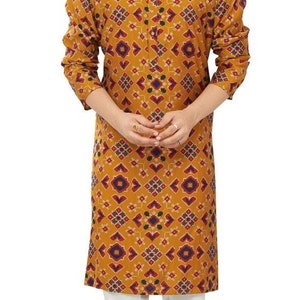 May include: A mustard yellow long-sleeved shirt with a geometric pattern in shades of red, blue, and white. The shirt has a mandarin collar and a button closure.
