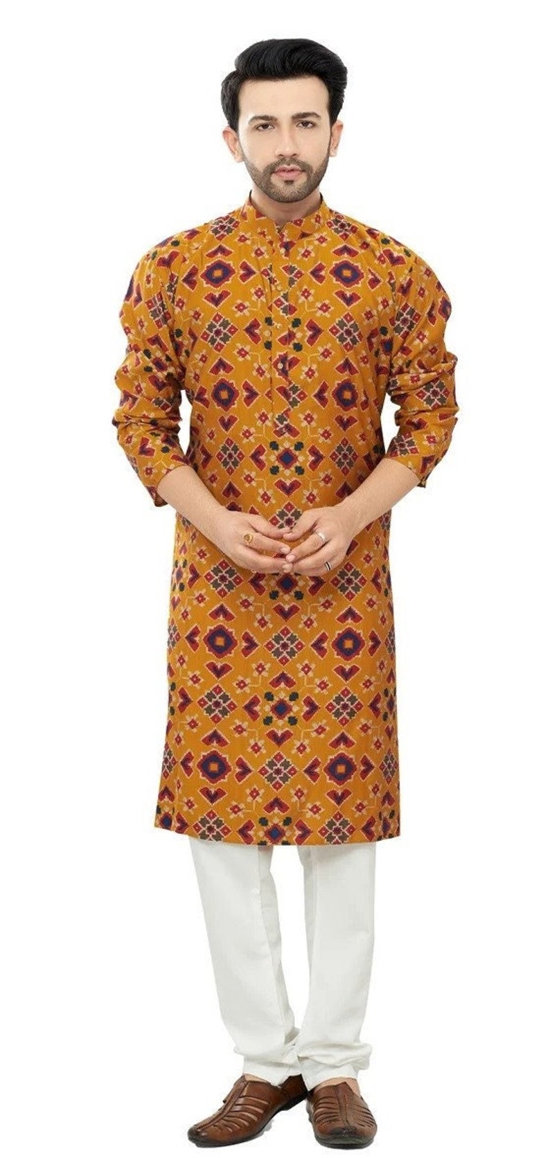 May include: A mustard yellow long-sleeved shirt with a geometric pattern in shades of red, blue, and white. The shirt has a mandarin collar and a button closure.