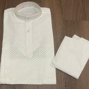 May include: White cotton kurta with a checkered pattern and a button closure. The kurta comes with a matching white cotton pajama.