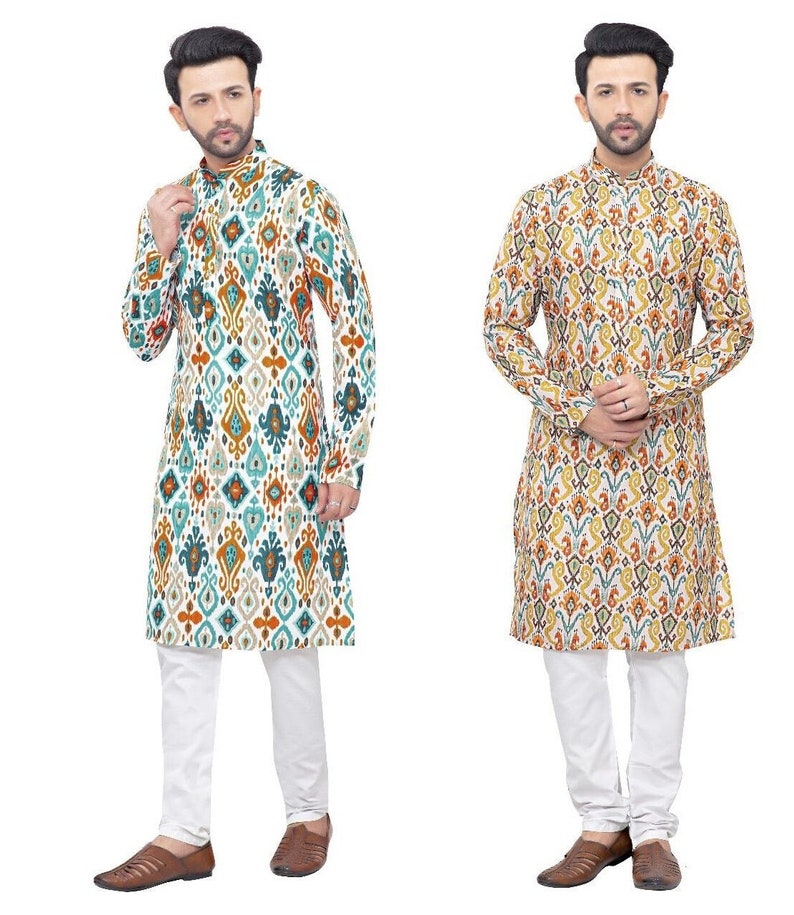 May include: Two long-sleeved shirts with a white background and a colourful geometric pattern. The shirts have a mandarin collar and a button closure. The shirts are paired with white trousers.
