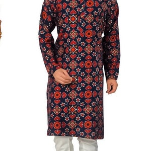 May include: A navy blue long-sleeved kurta with a red and white geometric pattern. The kurta is paired with white pants and brown shoes.