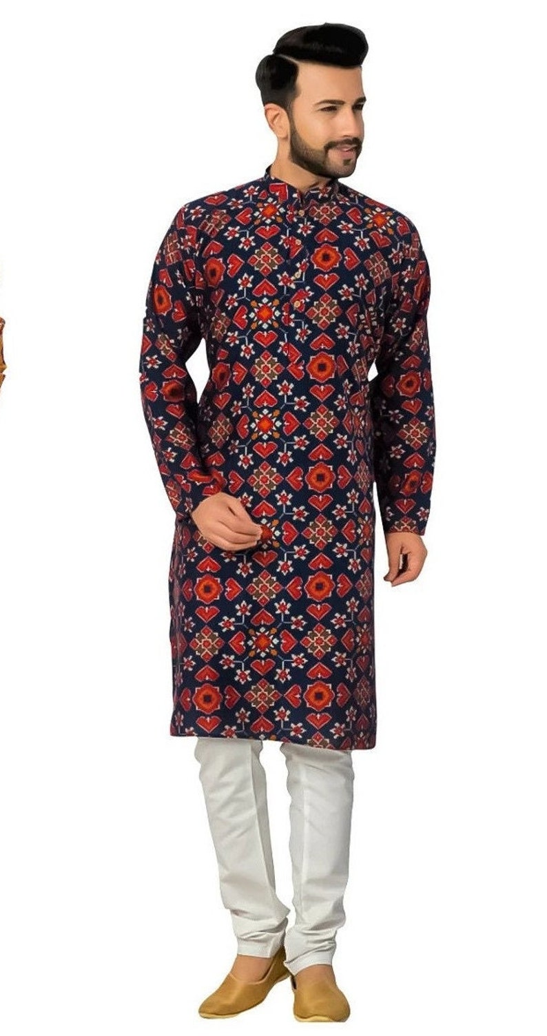 May include: A navy blue long-sleeved kurta with a red and white geometric pattern. The kurta is paired with white pants and brown shoes.