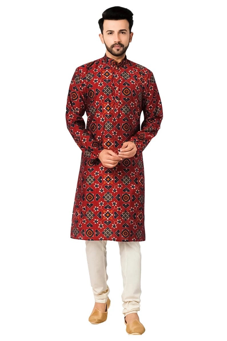 May include: A red long-sleeved kurta with a geometric pattern. The kurta has a mandarin collar and a button closure. The model is wearing white pants and brown shoes.